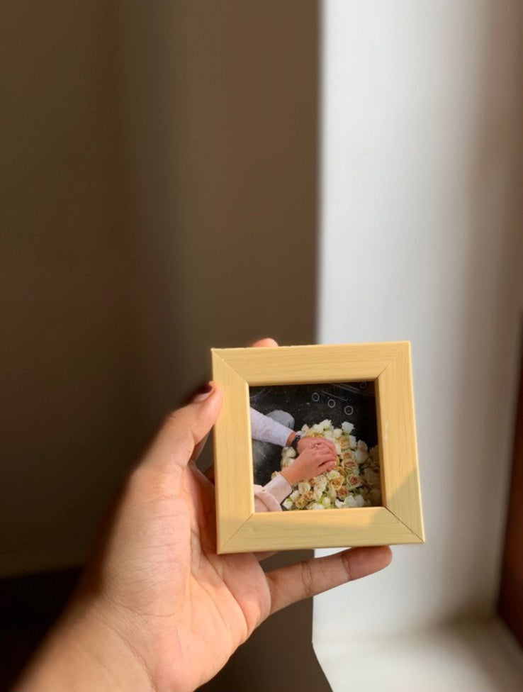 Hand holding small yellow handcrafted photo frame with picture inside, affordable decorative gift