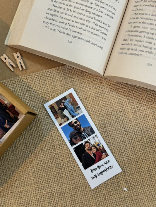 Handcrafted personalized photo strip with 3 prints placed on textured surface with book and pen