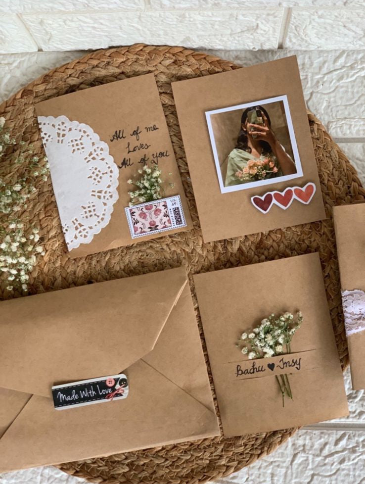 Handcrafted vintage-style greeting cards with envelopes and decorative elements arranged on surface
