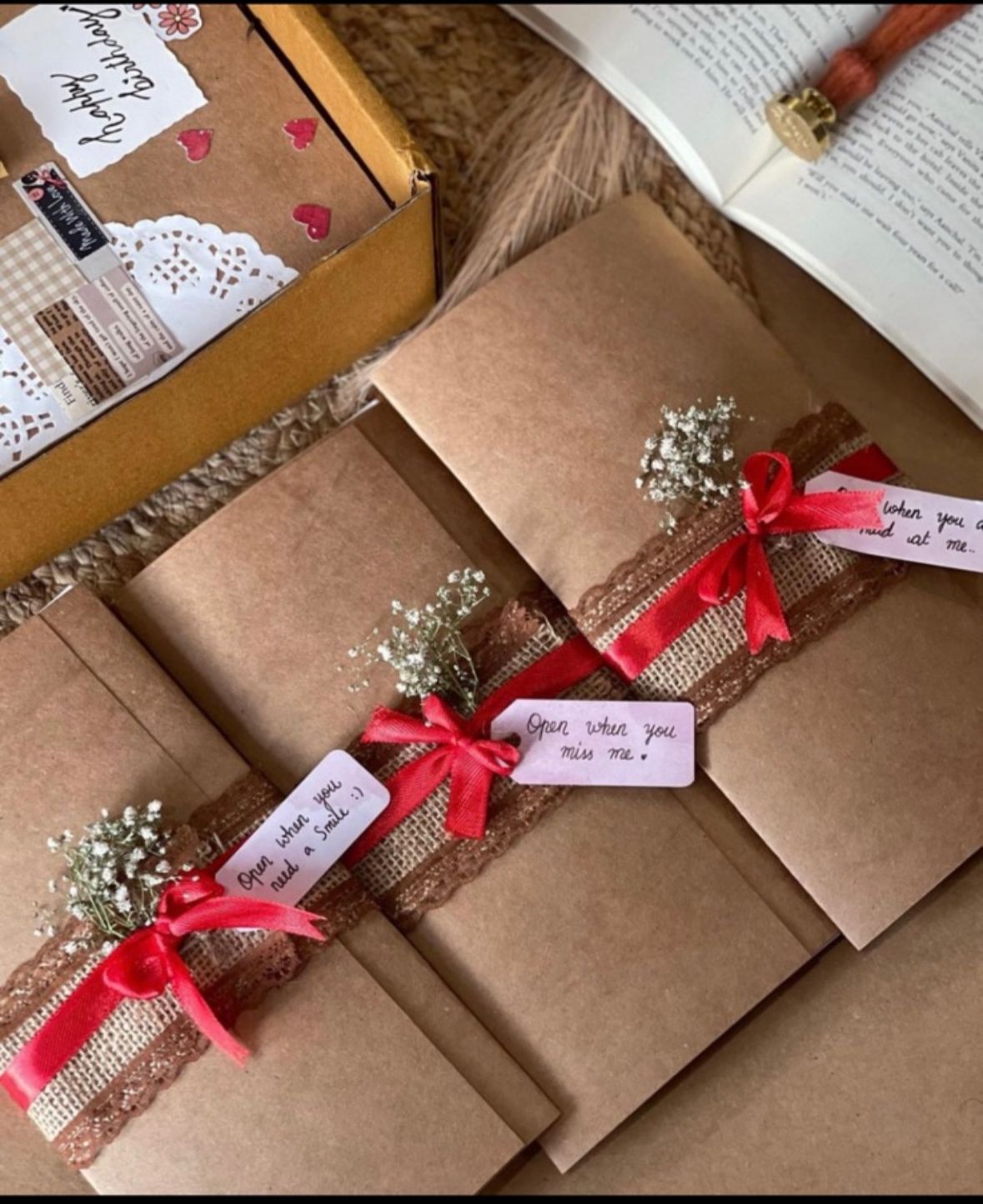 Handcrafted vintage brown paper letter tied with red ribbon and flowers, nostalgic romantic gift