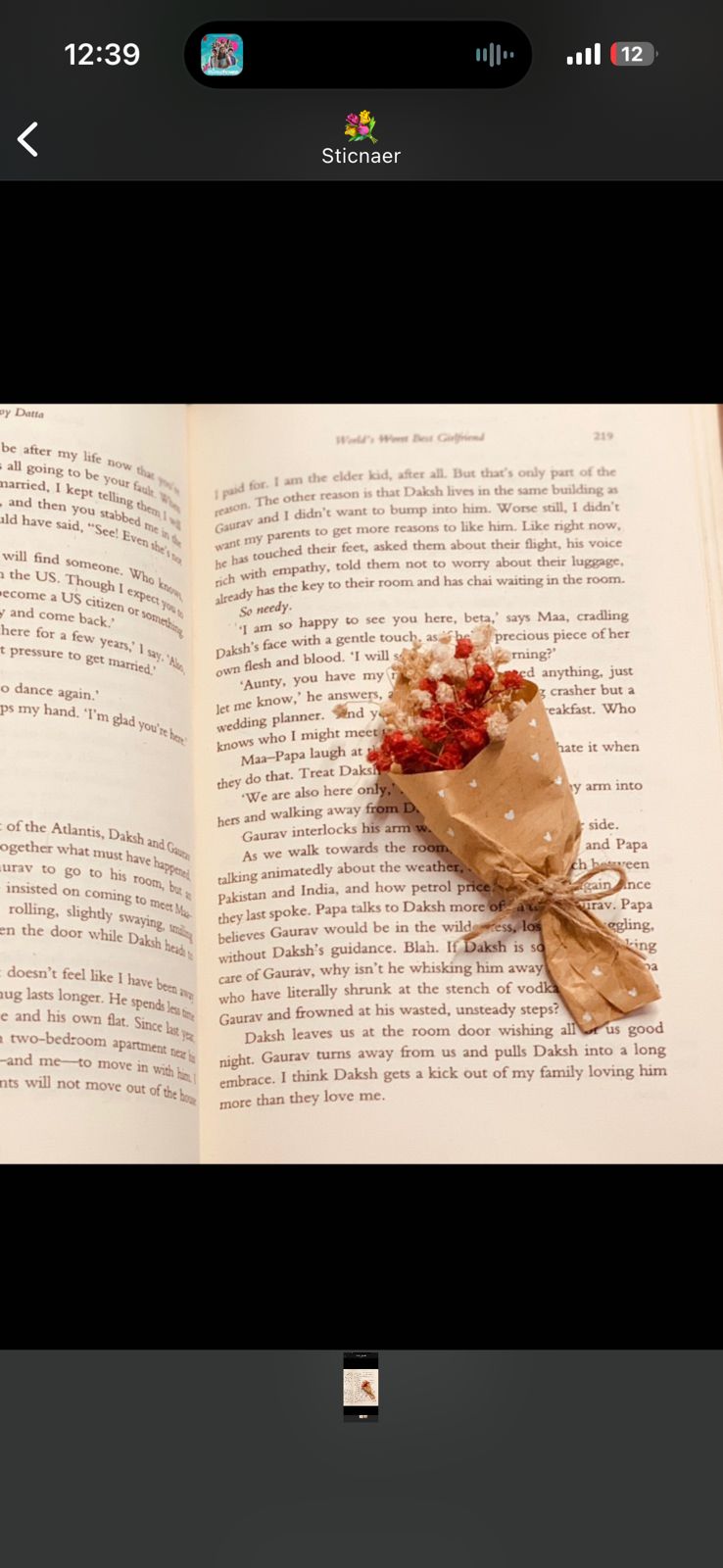Small handcrafted bouquet placed on open book, affordable floral gift under 100 rupees