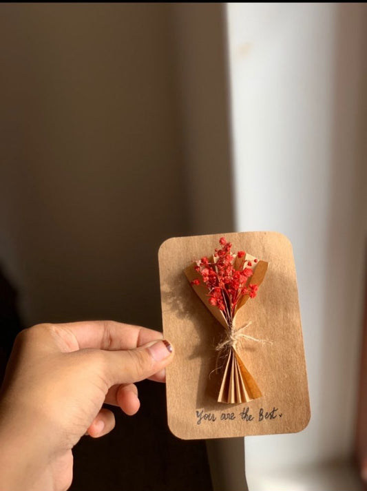 Hand holding handcrafted greeting card with bouquet floral design, affordable gift