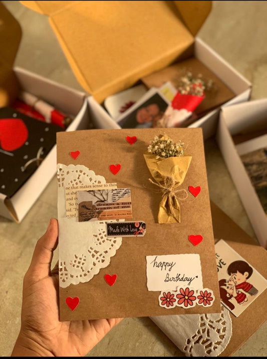 Handcrafted birthday greeting card with envelope, red hearts, golden bow, and attached photo